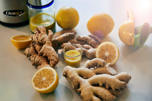 photo of ginger shot in glass with ginger root and lemon