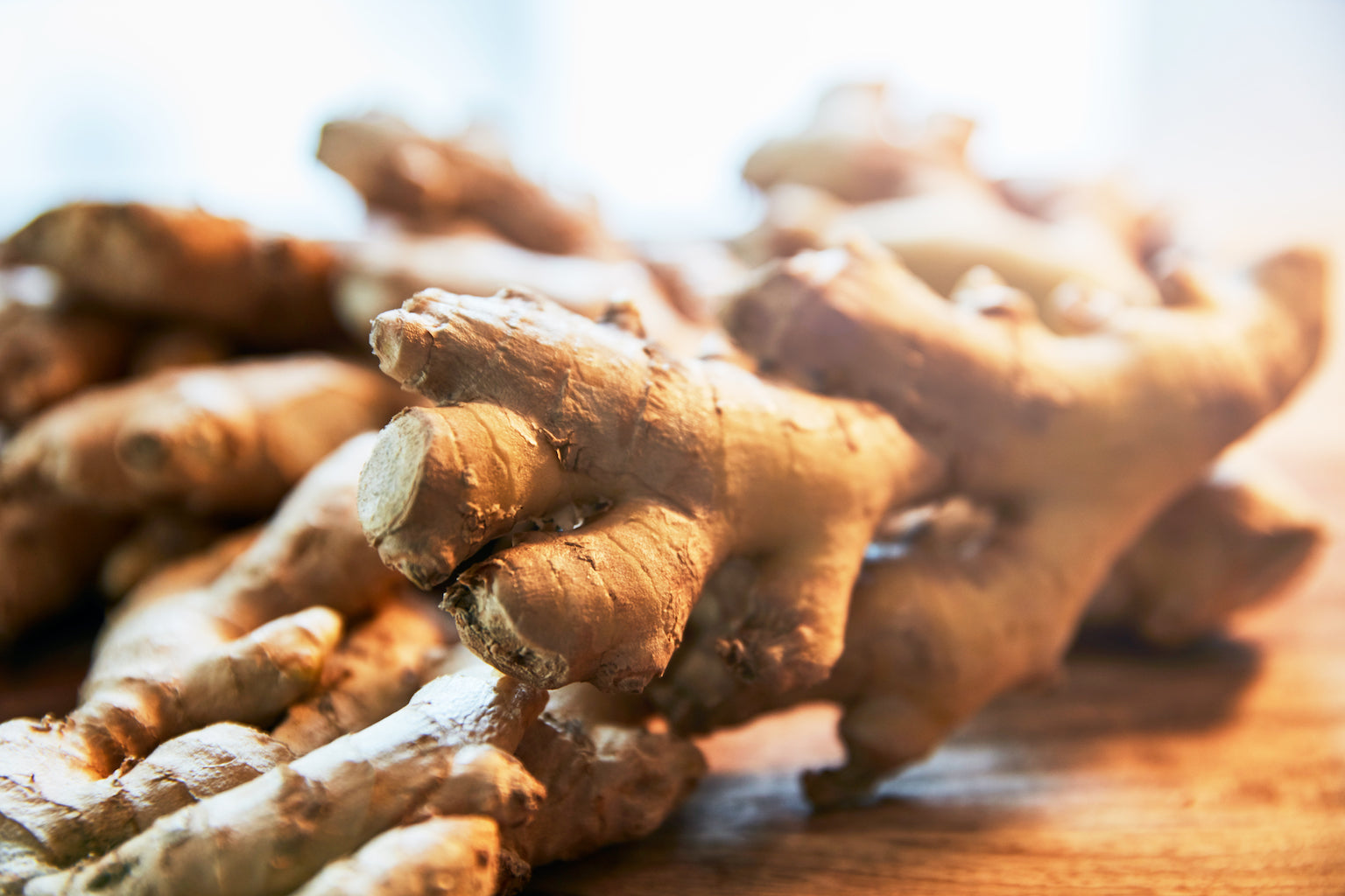 piles of ginger on wooden chopping board