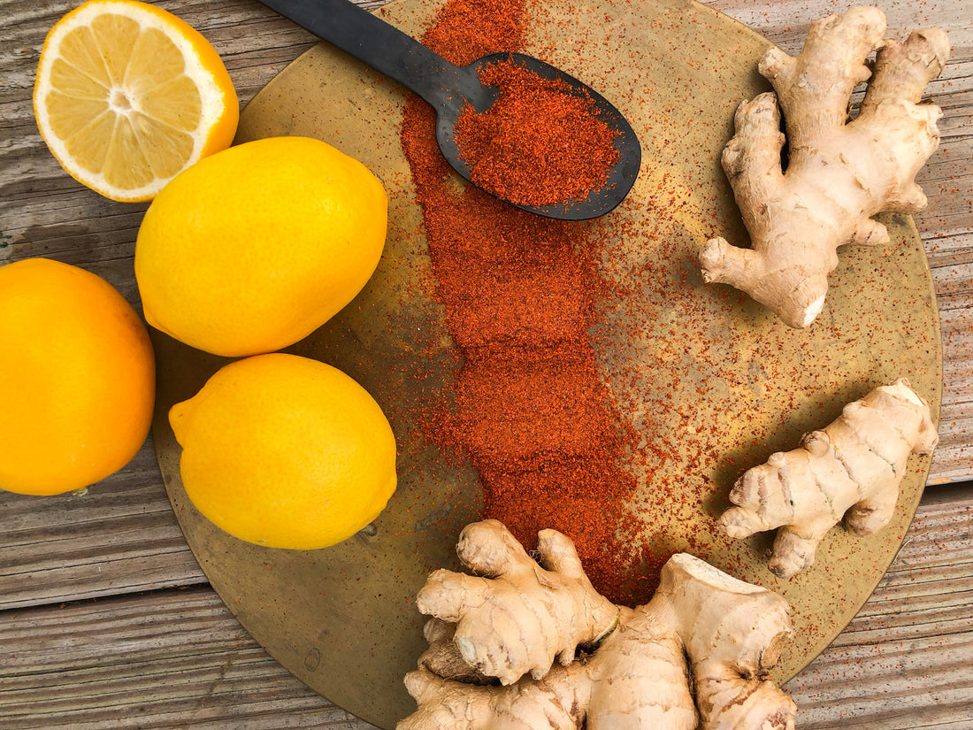 lemon cayenne and ginger ingredients on a wooden surface