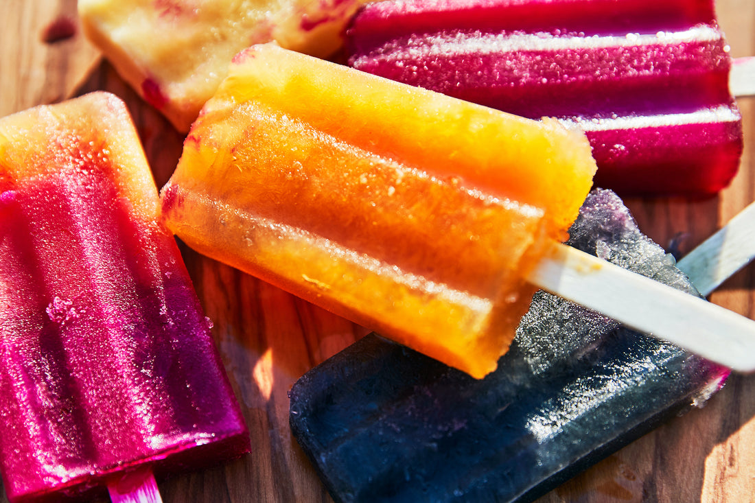 popsicles stacked on a wooden surface 
